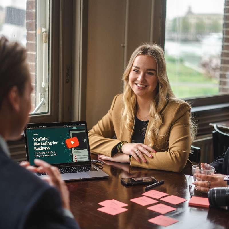 Overleg aan tafel met een laptop die YouTube Marketing for Business toont