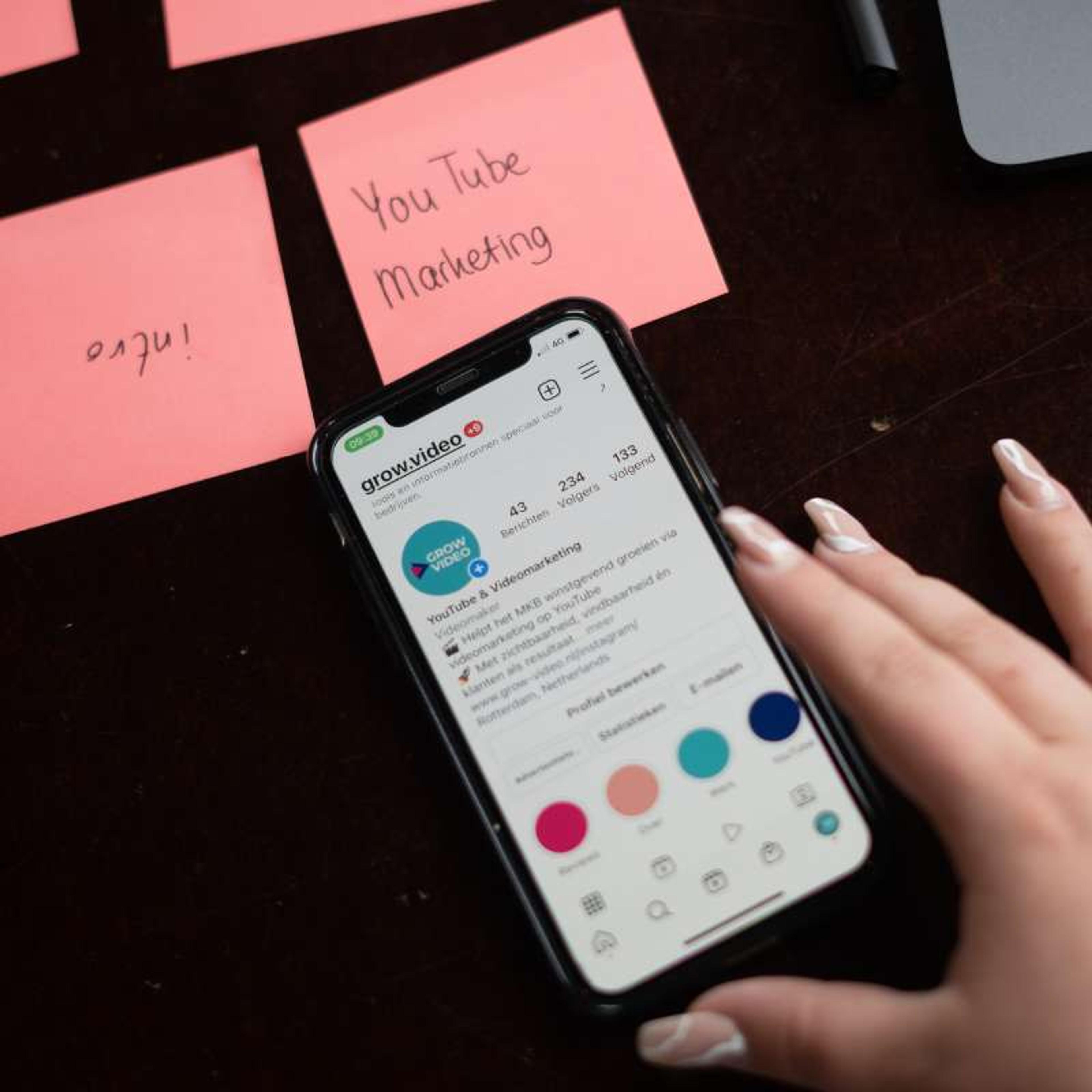 Smartphone met een YouTube-kanaal naast post-its over YouTube-marketing