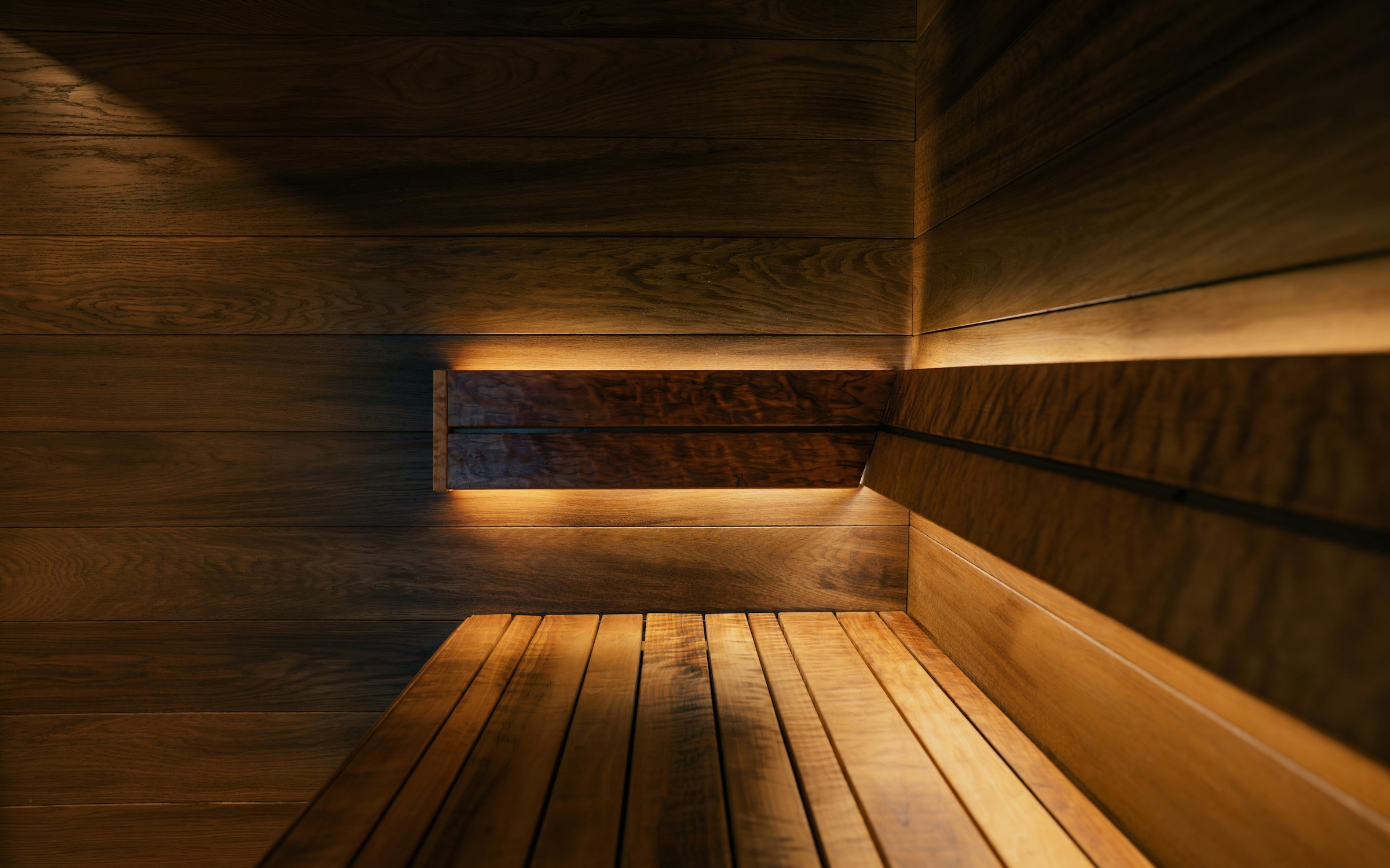 Intérieur d'un sauna en bois précieux, éclairage ambré