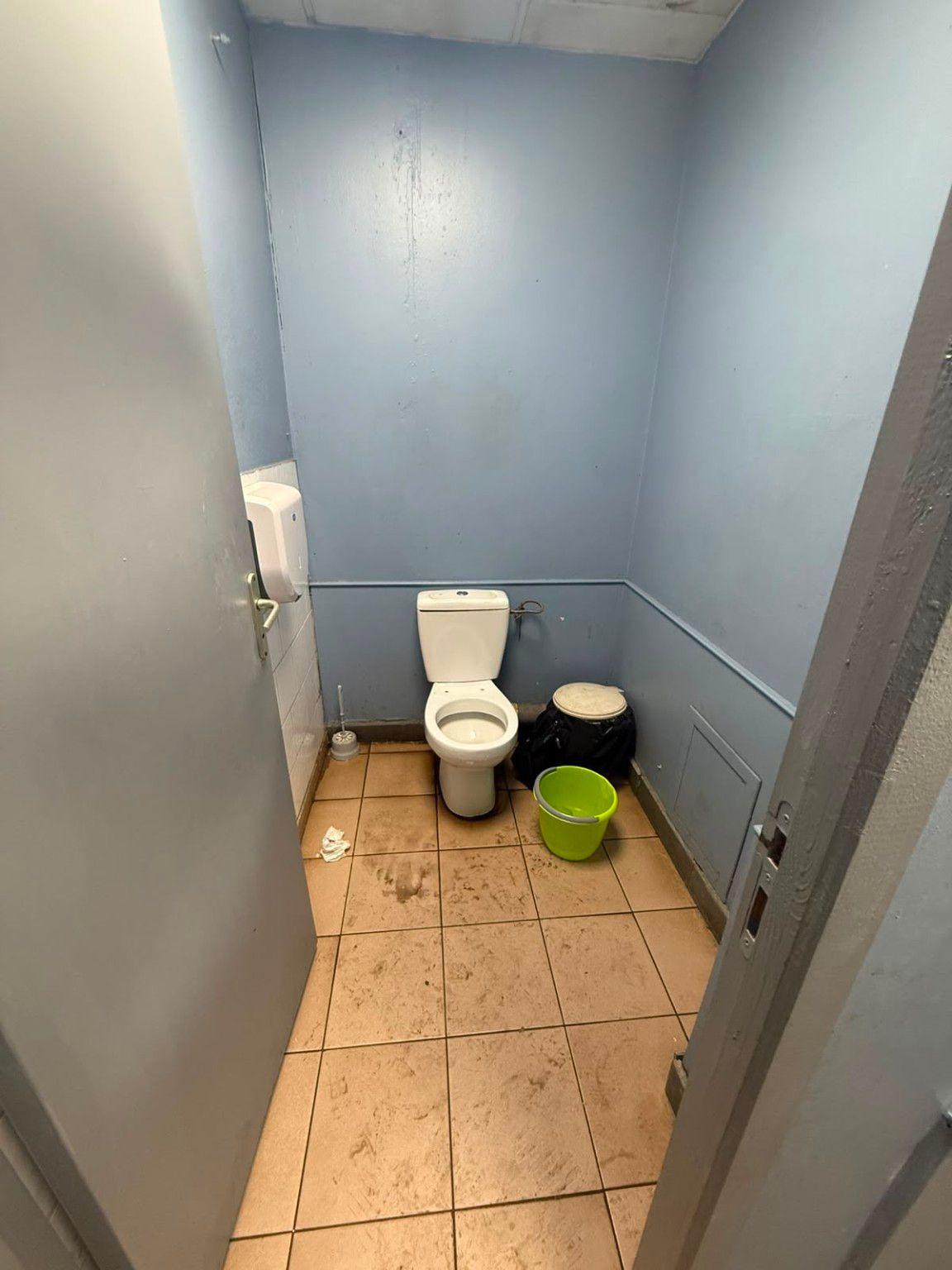 Cabine WC avant travaux : murs peints marqués et sol carrelé encrassé
