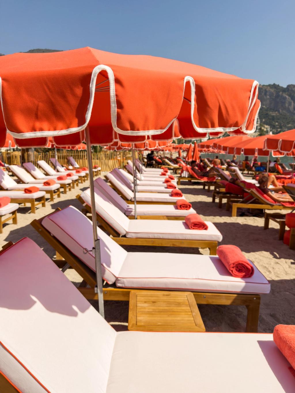 Orange umbrellas and sunlounges on a beach