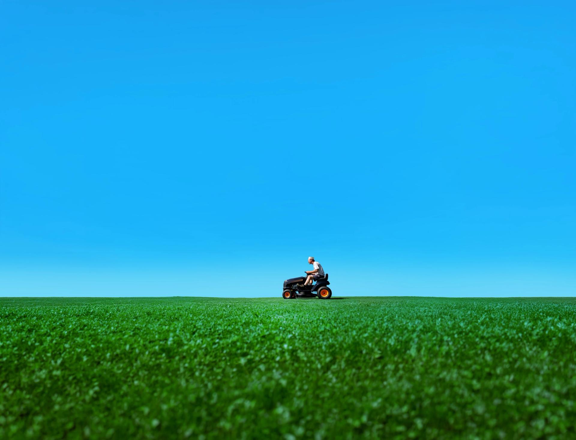 Lawnmower Man riding across a green field