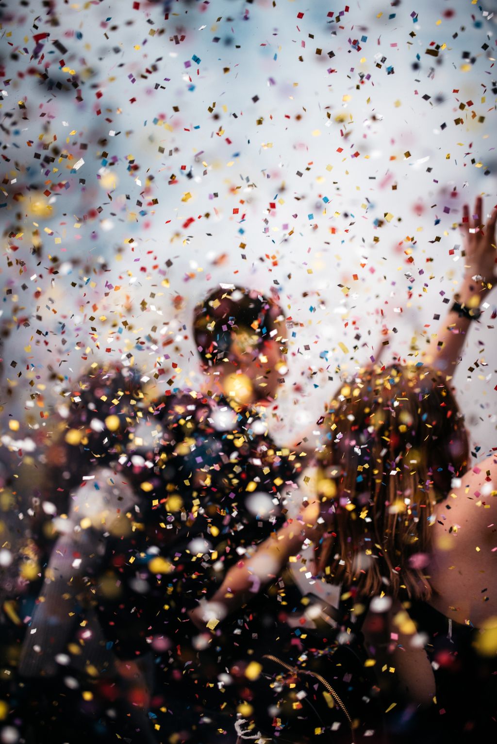Crowd celebrating beneath falling confetti