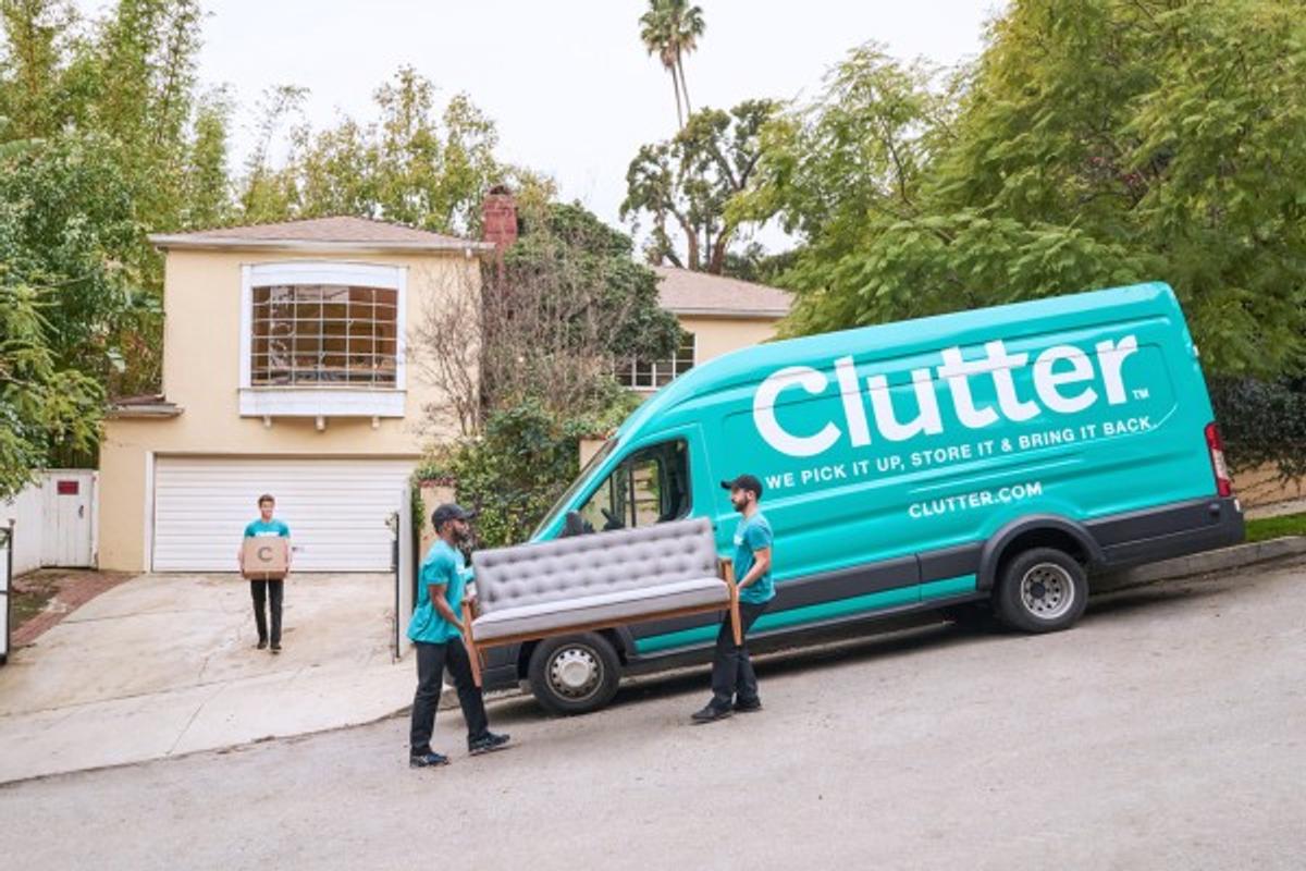 A teal van lettered "Clutter — we pick it up, store it & bring it back," as movers carry a couch.
