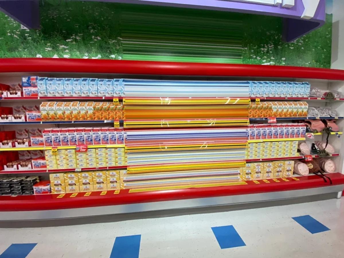 A supermarket dairy shelf stocked with plain cartons labeled "St" and "Milk".