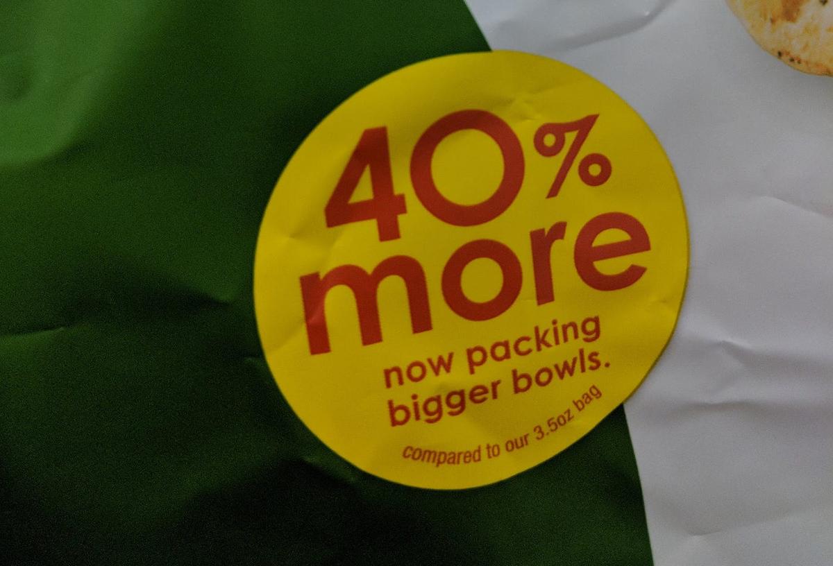Yellow sticker on a chip bag reading "40% more — now packing bigger bowls. compared to our 3.5oz bag".