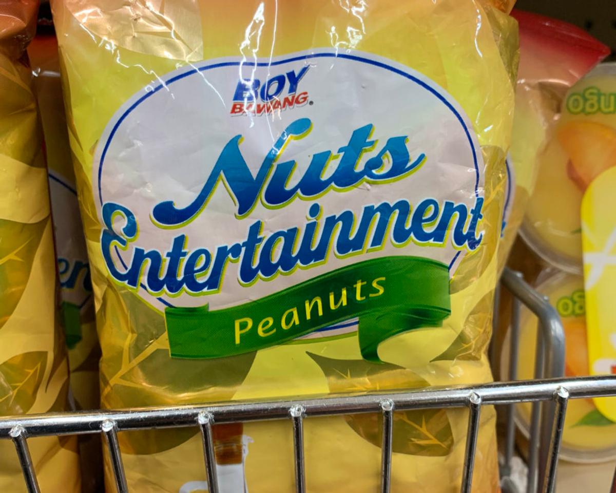 A yellow bag of Boy Bawang peanuts on a store shelf, branded "Nuts Entertainment."