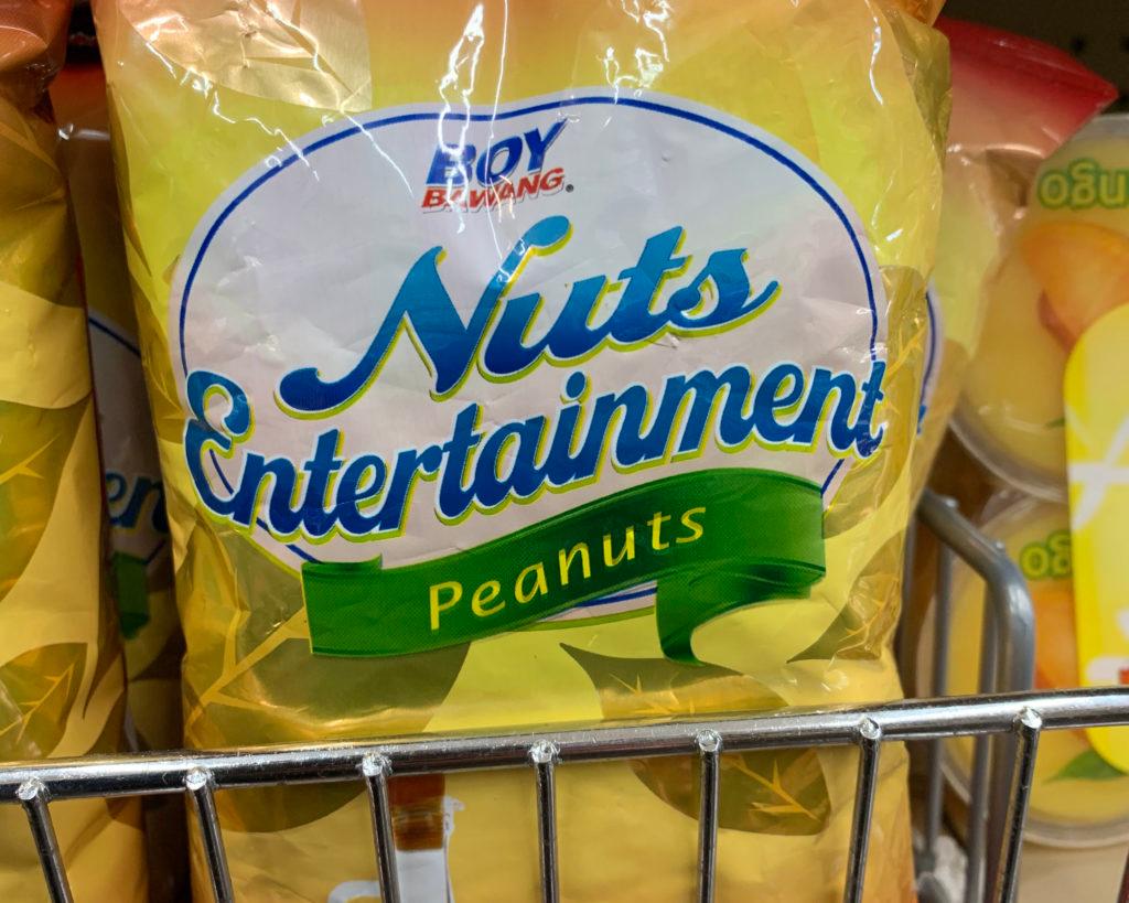 A yellow bag of Boy Bawang peanuts on a store shelf, branded "Nuts Entertainment."