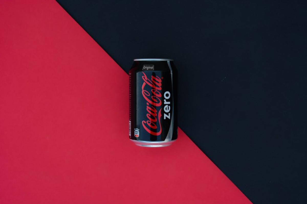 A black can of Coca-Cola Zero on a red and black background.