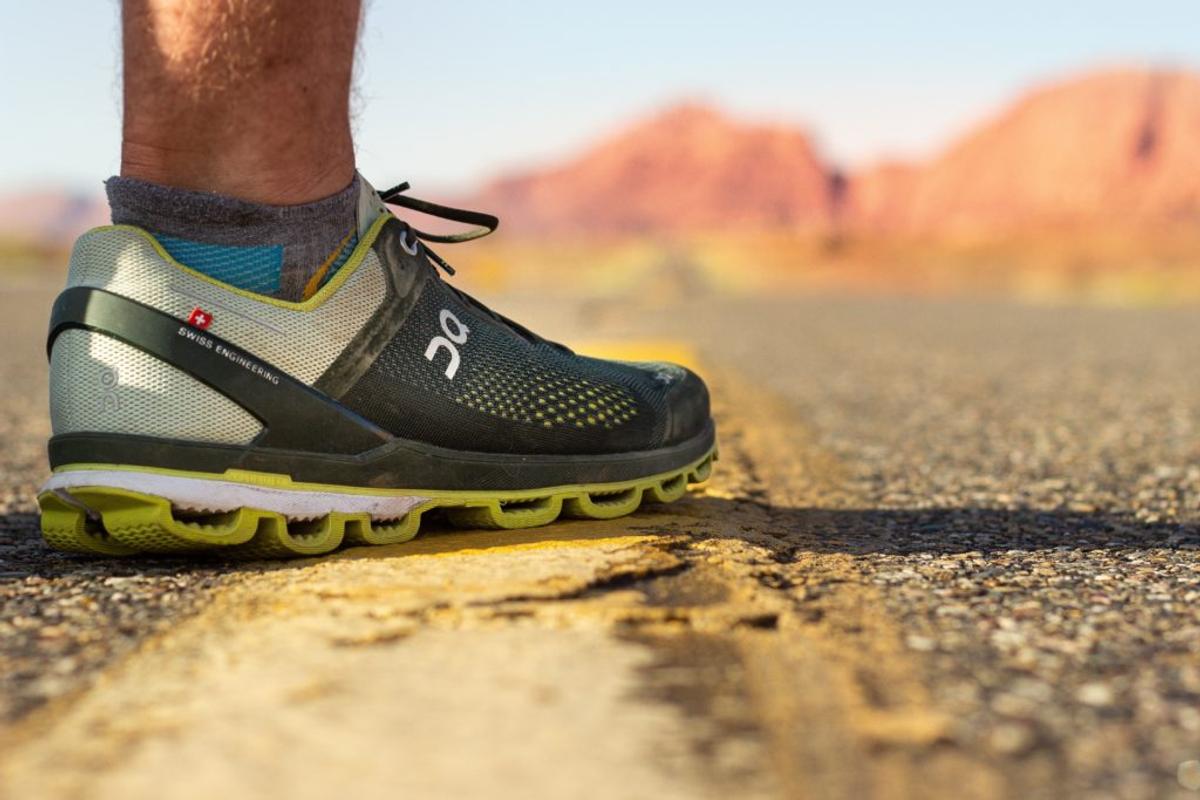 Close-up of an On running shoe with hollow CloudTec pods along its sole, on a desert road.