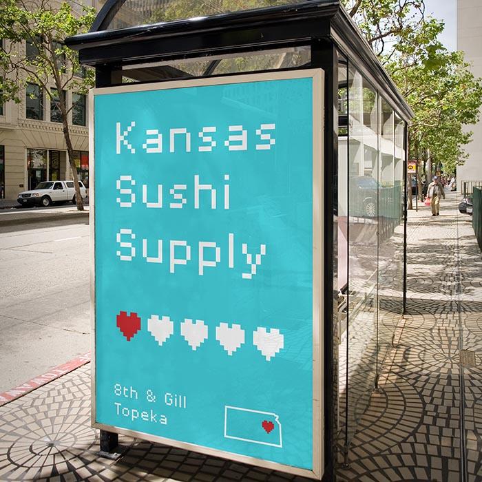 A bus shelter ad in pixel type reading "Kansas Sushi Supply, 8th & Gill, Topeka" with pixel hearts.