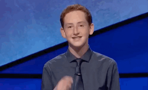 A young Jeopardy contestant smiling awkwardly at the camera against the show's blue set.