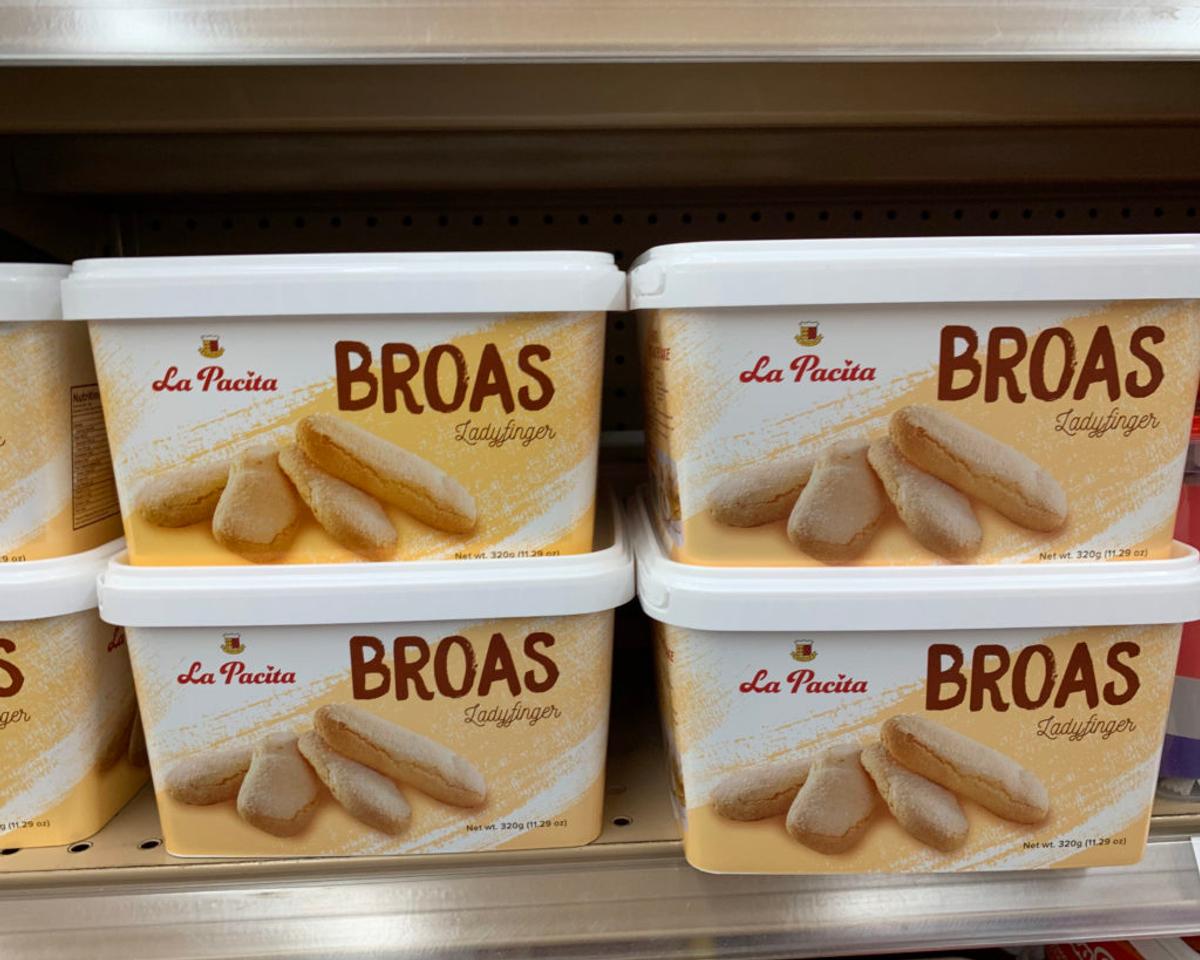 Tubs of "La Pacita BROAS Ladyfinger" cookies stacked on a supermarket shelf.