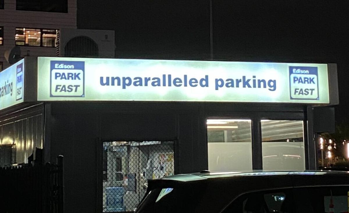 Lit garage sign reading "unparalleled parking" between two Edison ParkFast logos.