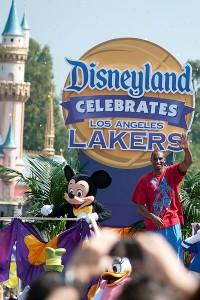 A parade float reading "Disneyland celebrates Los Angeles Lakers" with Mickey Mouse and Kobe Bryant waving.