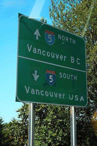 Green highway sign: Interstate 5 north to "Vancouver BC," south to "Vancouver USA."