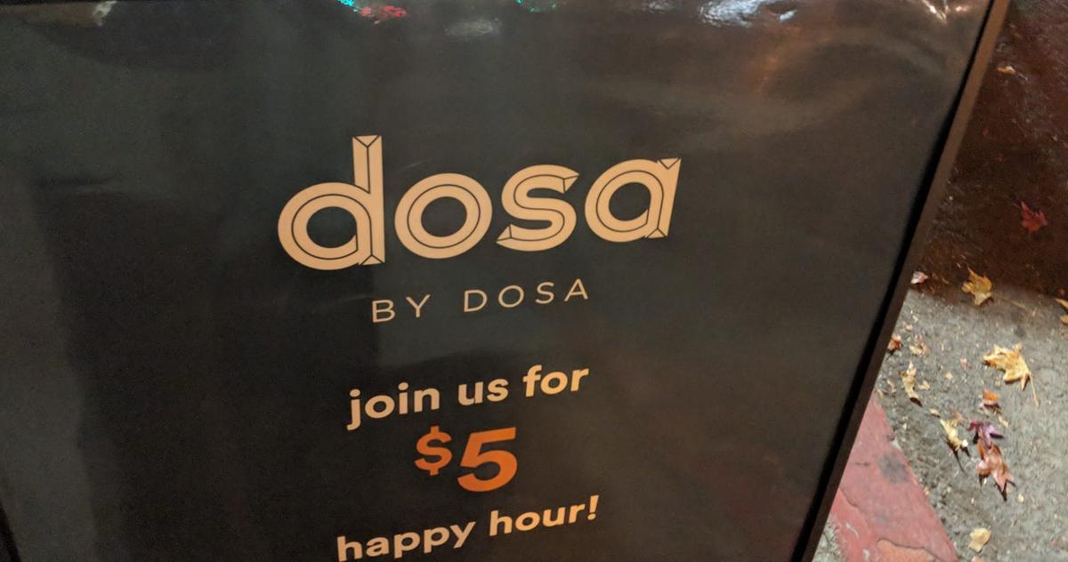 Sidewalk sign reading "dosa BY DOSA — join us for $5 happy hour!"