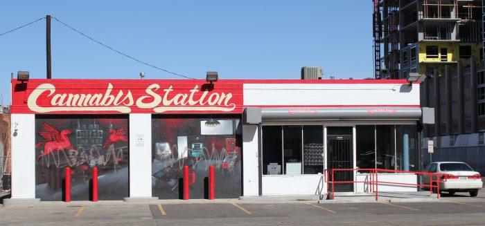 A storefront painted red with "Cannabis Station" in cream script above murals of flying red horses.