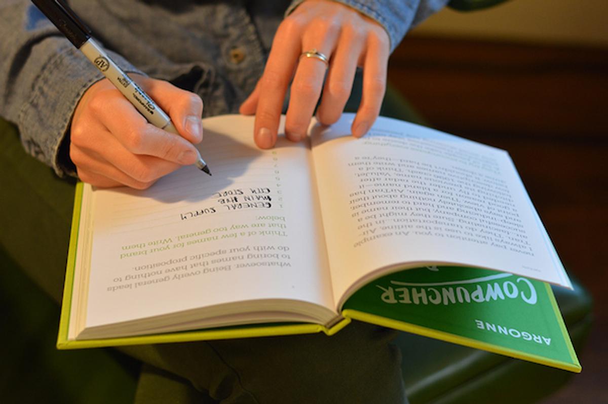 A hand writing in the workbook’s naming exercises