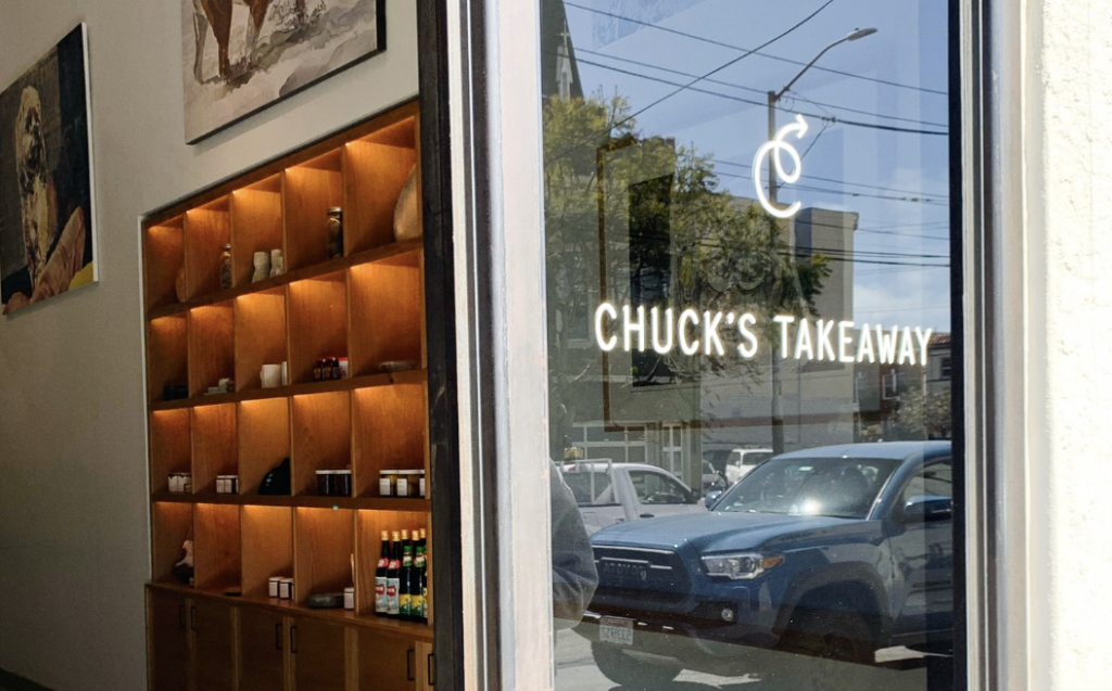 "Chuck's Takeaway" lettered on the shop window, shelves of jars and bottles inside