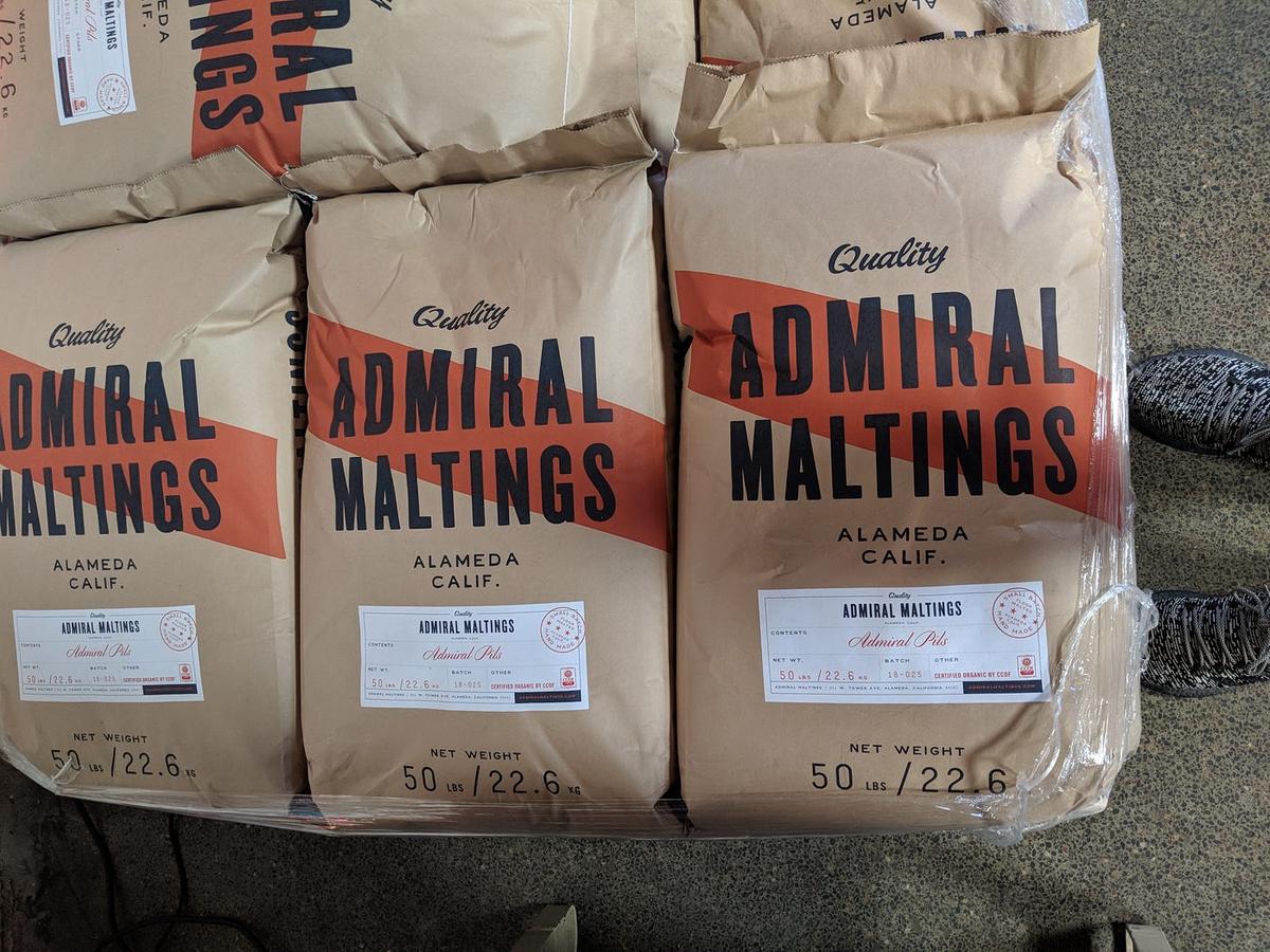 Stacked paper sacks reading "Quality Admiral Maltings, Alameda Calif., net weight 50 lbs."