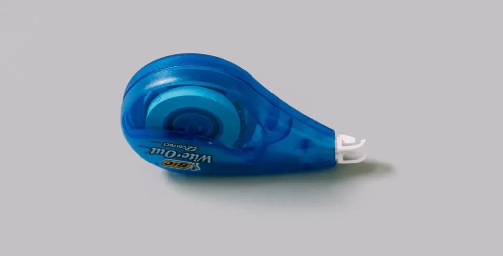 A blue Bic Wite-Out EZ Correct correction tape dispenser on a gray surface.
