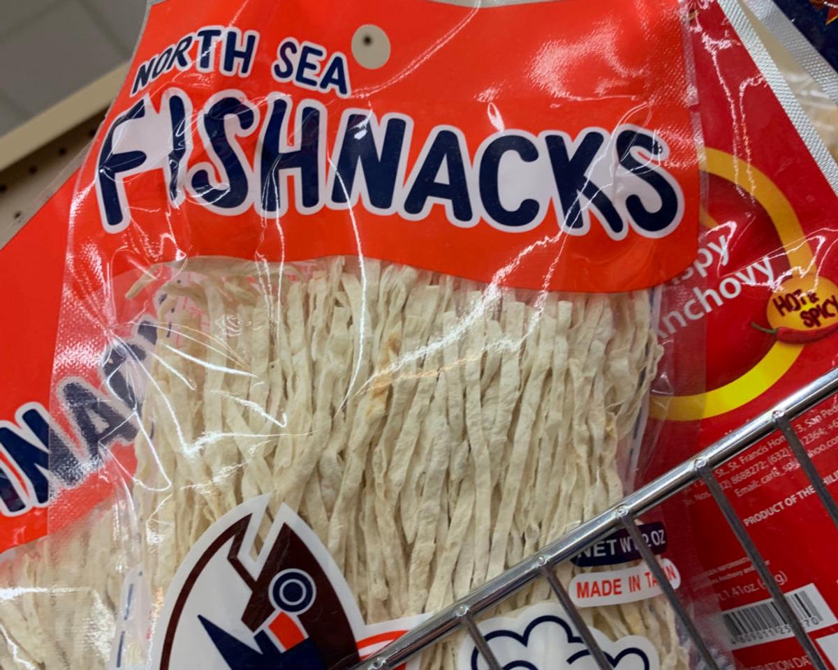 Red package of "North Sea Fishnacks" crispy anchovy, hot and spicy, filled with pale shredded fish.