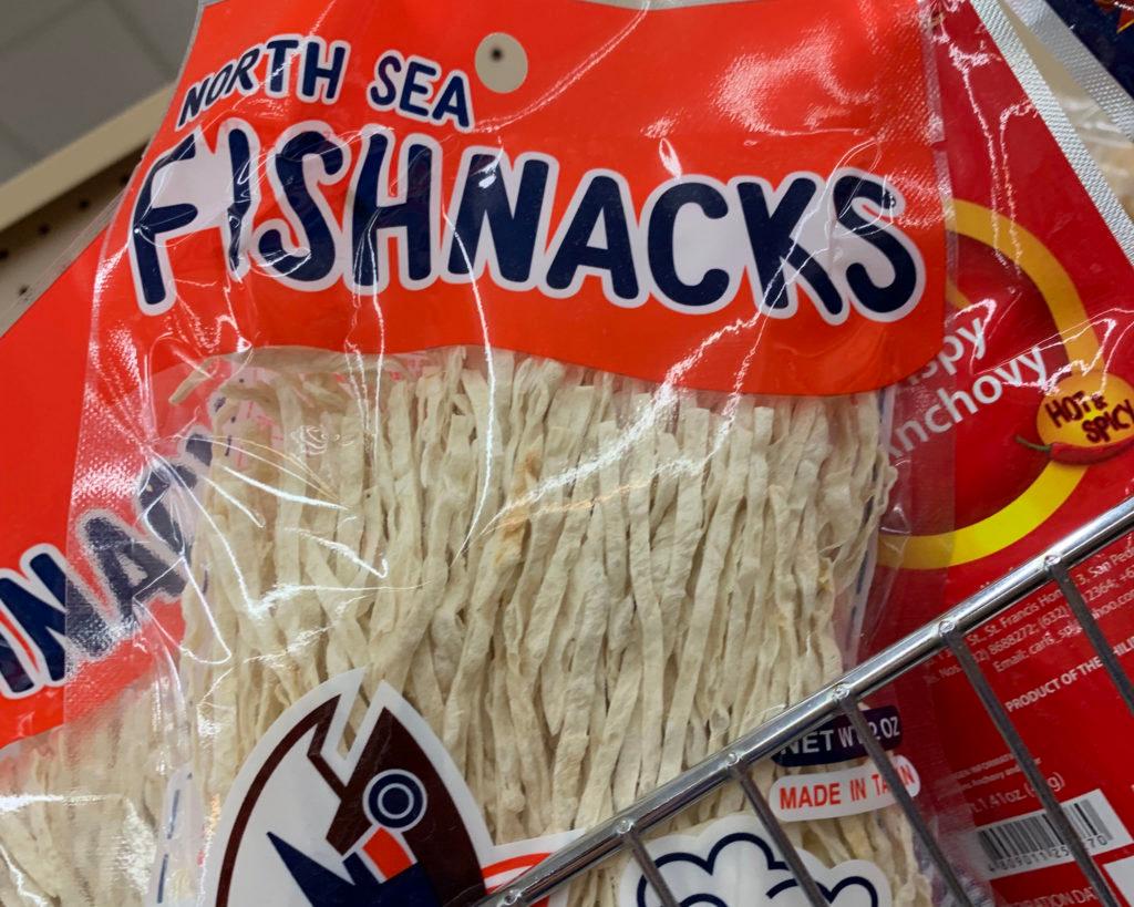 Red package of "North Sea Fishnacks" crispy anchovy, hot and spicy, filled with pale shredded fish.