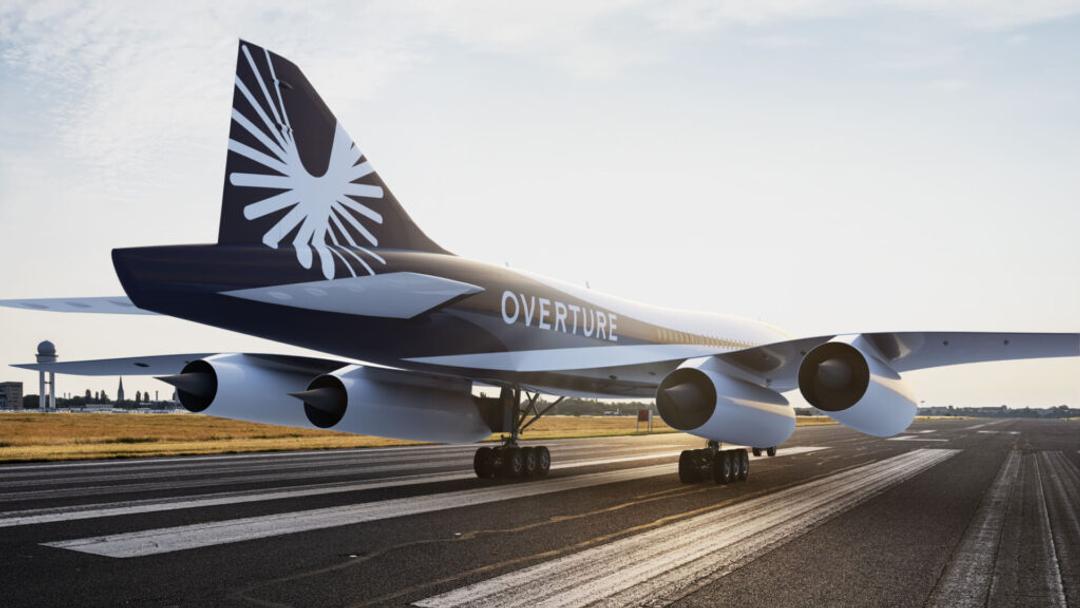 The Overture supersonic airliner on a runway at dawn, its name along the fuselage