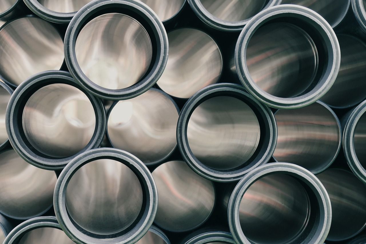 Close-up of stacked black plumbing pipes seen end-on at a construction site.