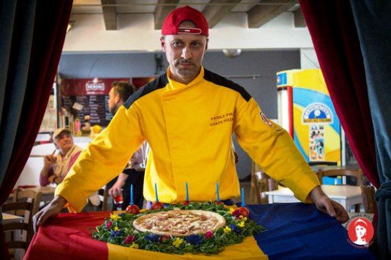 Vasile Pulbere con pizza speciale e bandiera della Romania