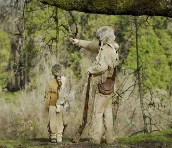 Old trapper and son in the woods