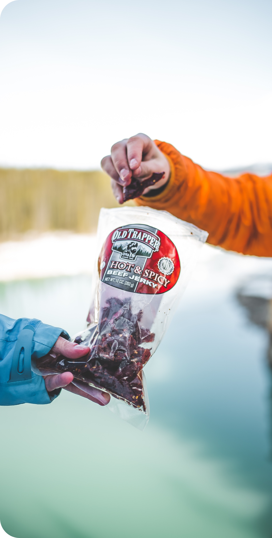 People holding and grabbing Old Trapper Beef Jerkey