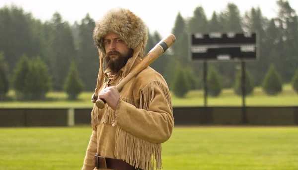 Old Trapper holding an old wooden bat