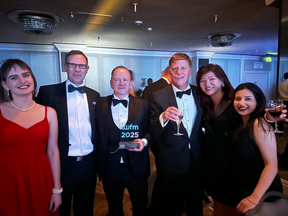Six members of the Datore team in black tie, holding the IWFM Impact Awards 2025 trophy.