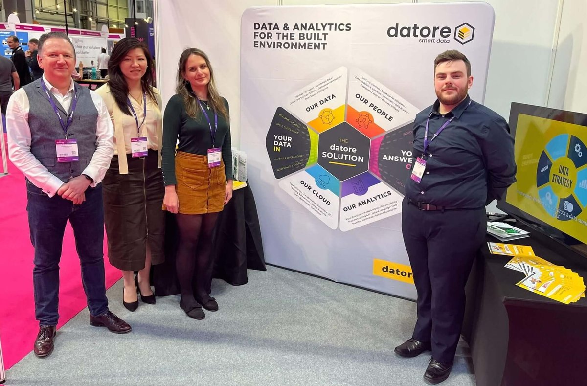 Four members of the Datore team standing beside the company's exhibition stand at The Workplace Event 2023.
