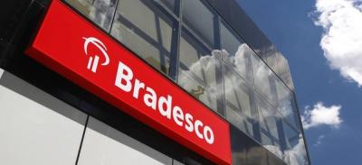 Fachada do banco Bradesco com céu azul ao fundo com nuvens 