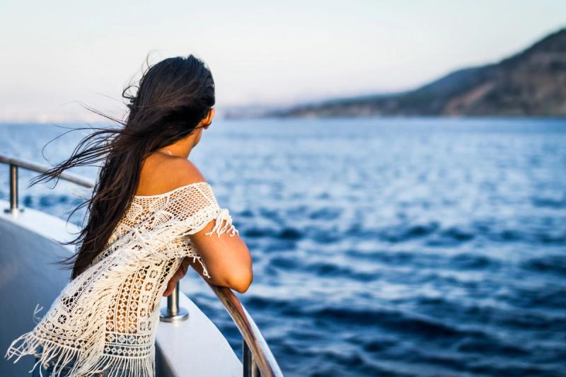 Woman on a boat watching the sea.