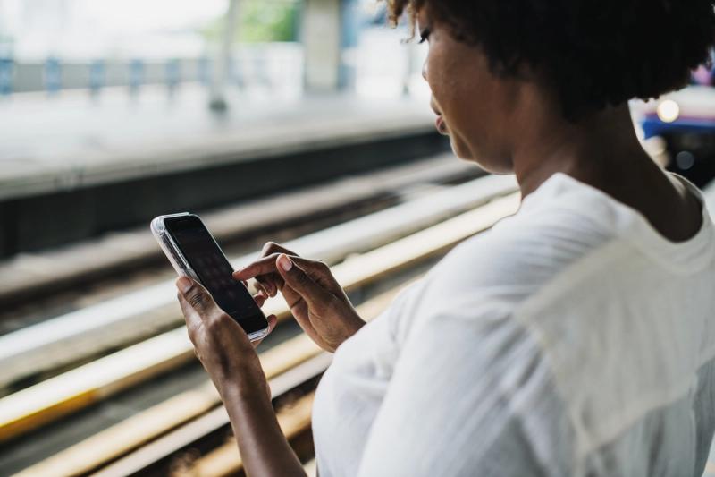 African woman from behind using her mobile phone.