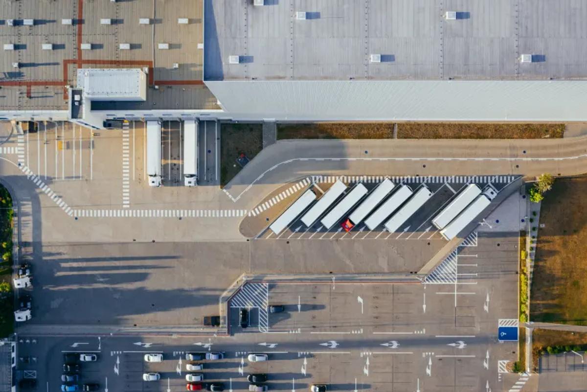 Vista aérea de un patio de vehículos y muelles de una bodega