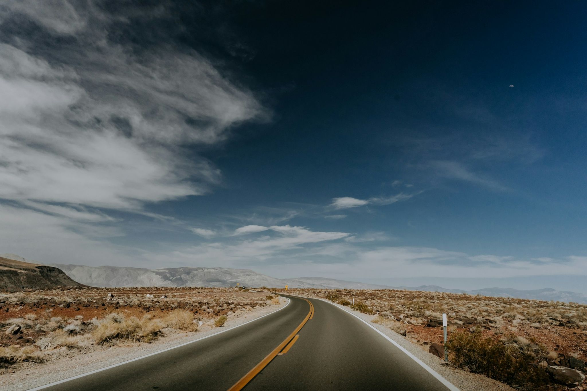 Open desert road running toward distant mountains