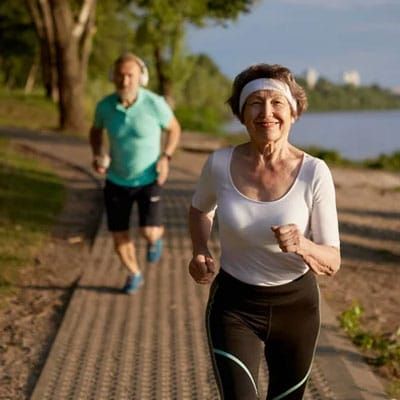 Older couple jogging together outside.