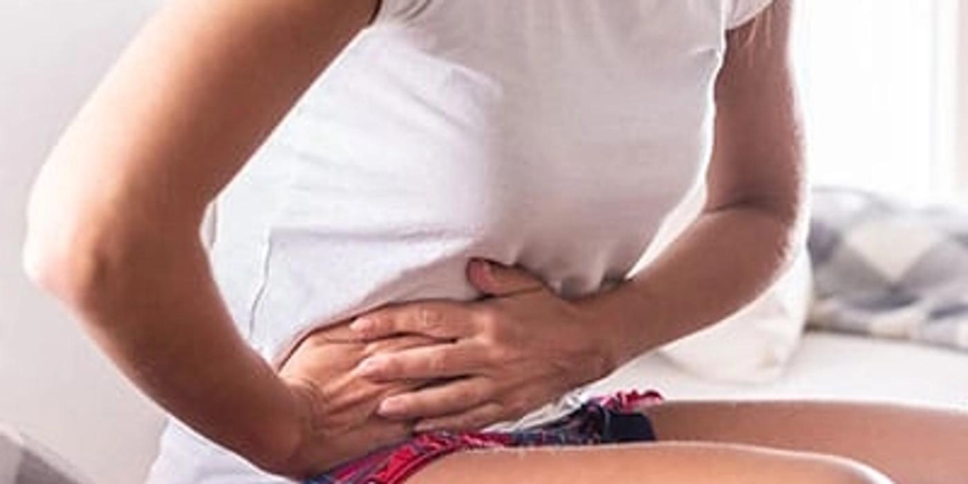 A woman is holding her side in pain.