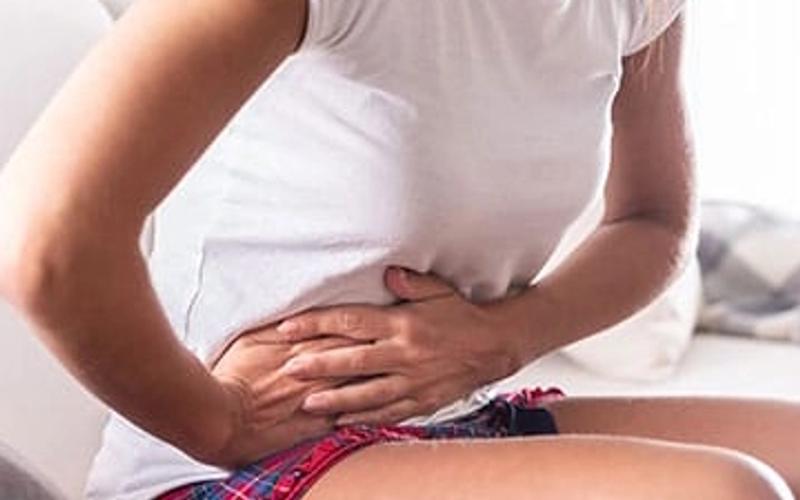 A woman is holding her side in pain.