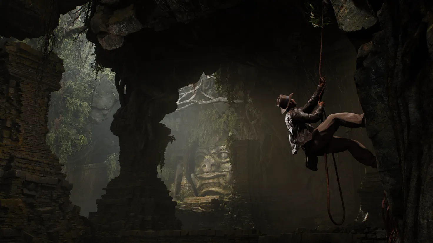 Indiana Jones uses his whip to climb a rock wall in the Demon's Tomb in the Indiana Jones and The Great Circle video game