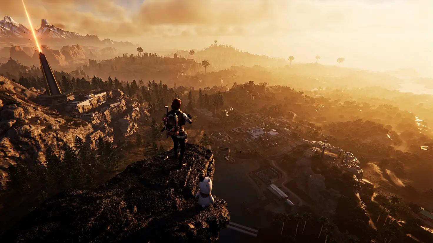 A player's character stands on a high cliff overlooking a settlement at sunset