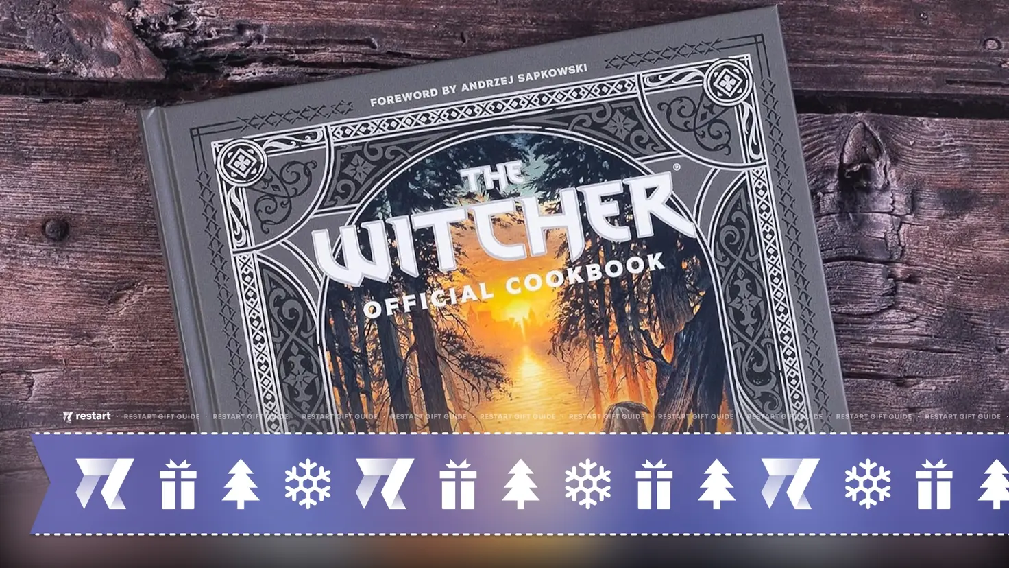 The Witcher Official Cookbook lies on a grey wooden surface