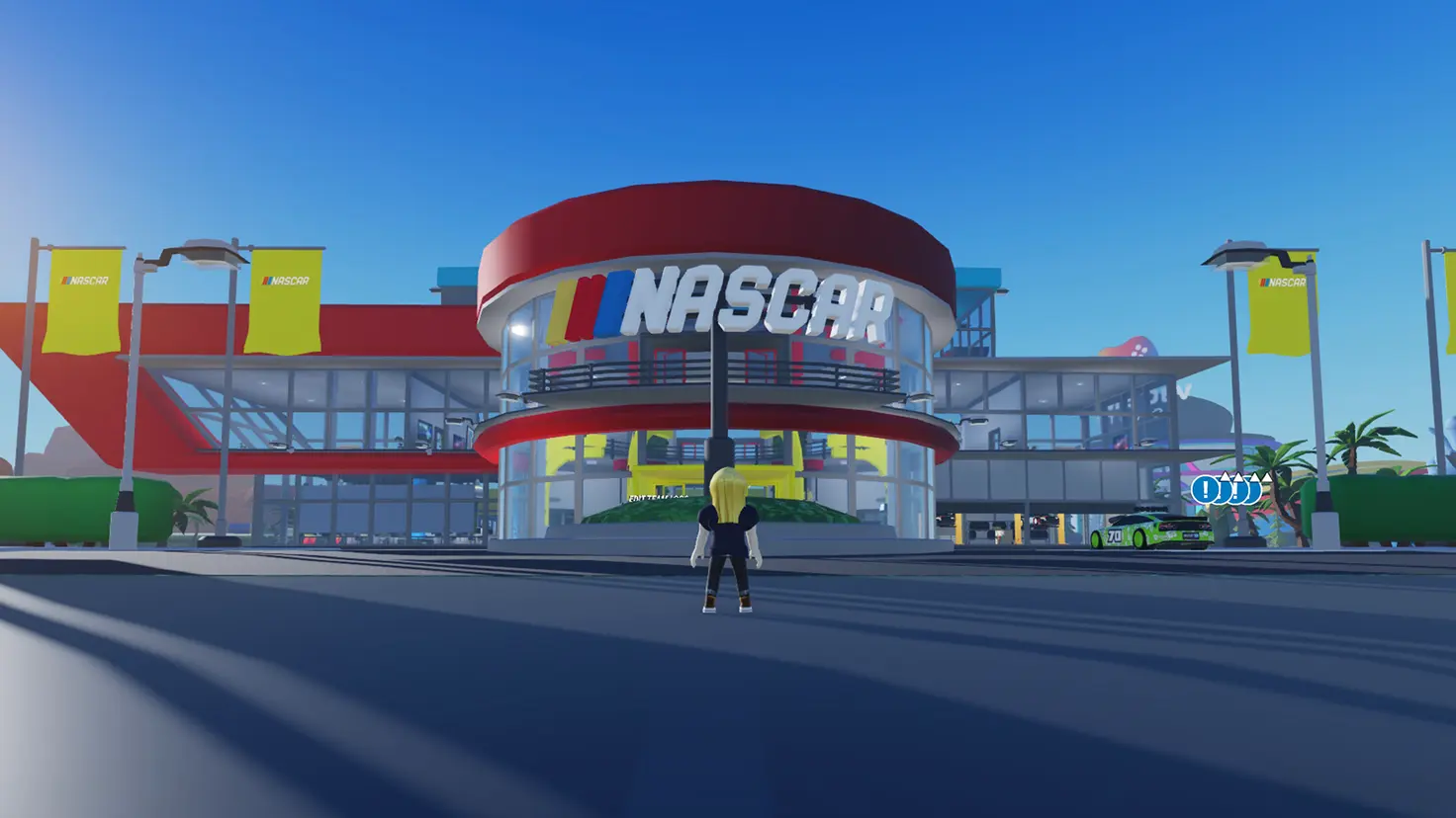 A Roblox player stands in front of the Team HQ area in the NASCAR Tycoon Roblox experience