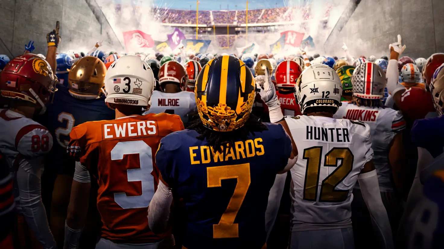 Football players walking through a stadium tunnel toward the field