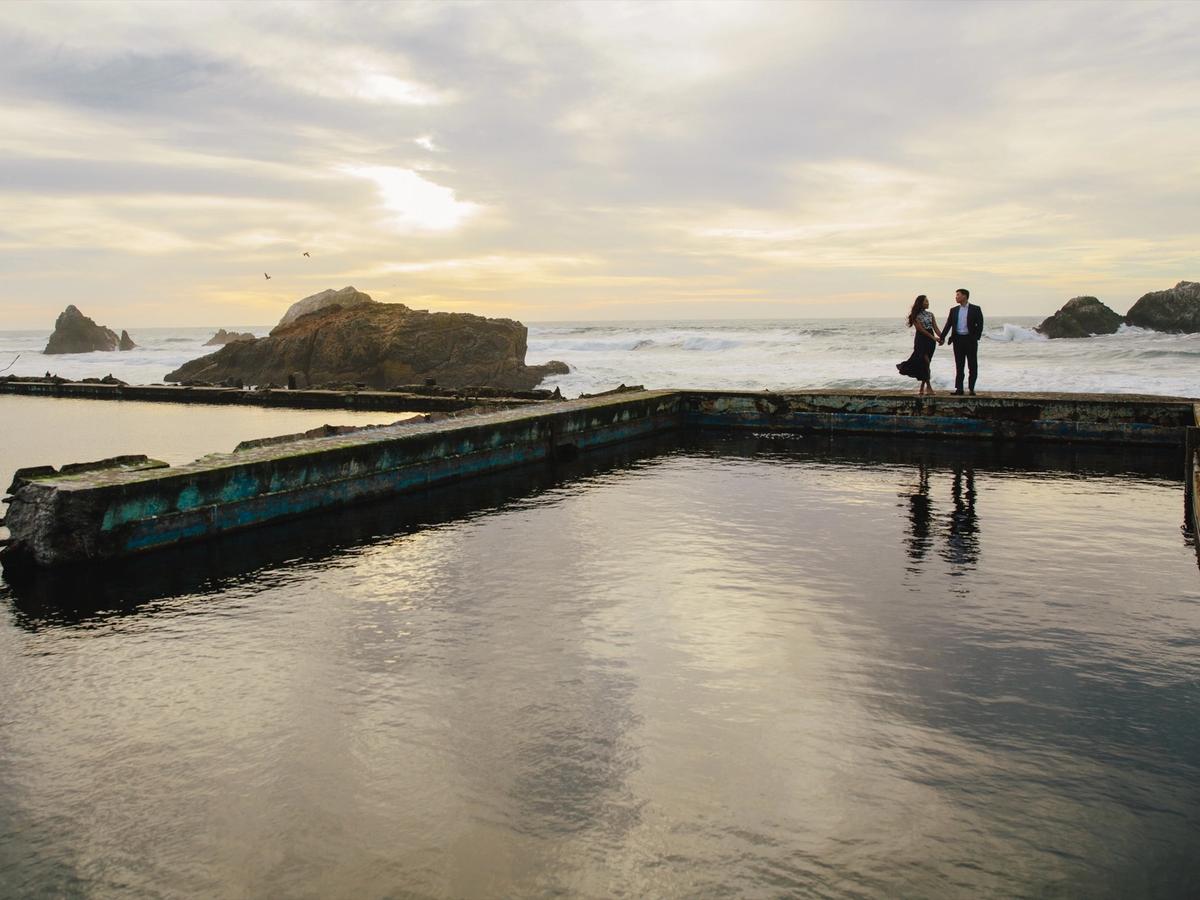 Tammy and Sang at the edge of the Sutro Baths ruins with the Pacific behind them.